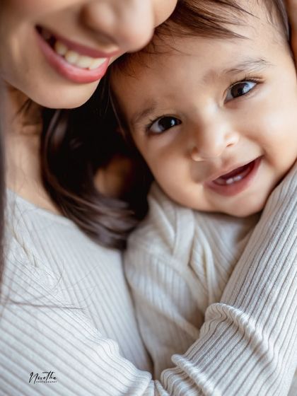 A close-up of a mother and her smiling baby.