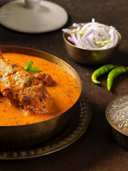 A detailed shot of the Chicken-e-Rubaruh, focusing on the garnishes and the texture of the curry.