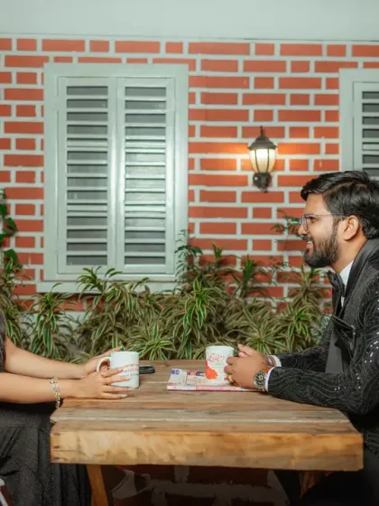A cozy cafe setting for a pre-wedding shoot. This image captures the couple sharing a conversation over coffee, creating a relatable and intimate scene that feels like a real date night.
