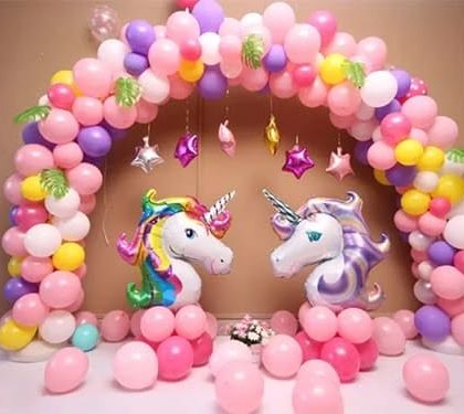 A magical unicorn themed party with a pastel balloon arch and two large unicorn head foil balloons.
