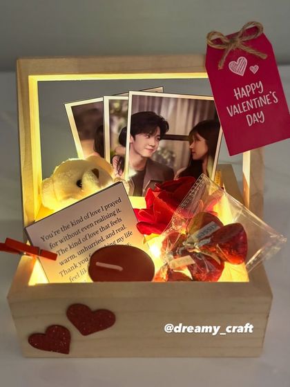 This lit-up Valentine's hamper creates a warm and romantic glow. It's a small wooden basket filled with photos, a teddy, a love note, and other sweet treats.