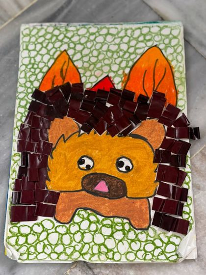 A close-up of the paper hedgehog craft, showing how small pieces of coloured paper were used to create the prickly texture of its spines.