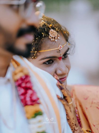 A sweet, intimate shot of the bride peeking over the groom's shoulder with a loving smile.