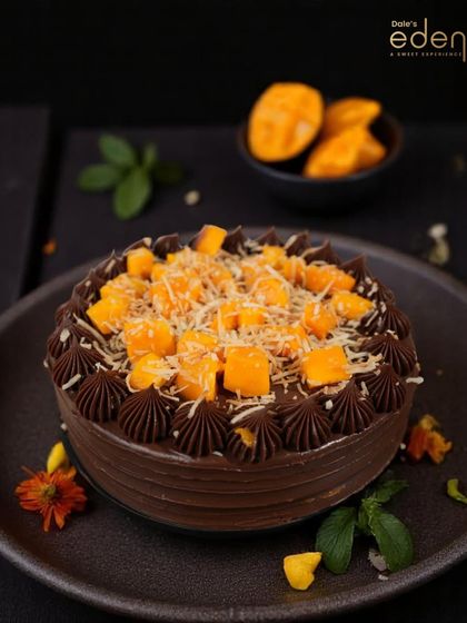 A rich chocolate cake gets a tropical upgrade with a generous topping of fresh mango chunks and grated white chocolate.