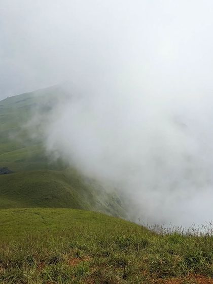 The dense fog rolling in, completely transforming the landscape during a winter trek to Nethravathi.