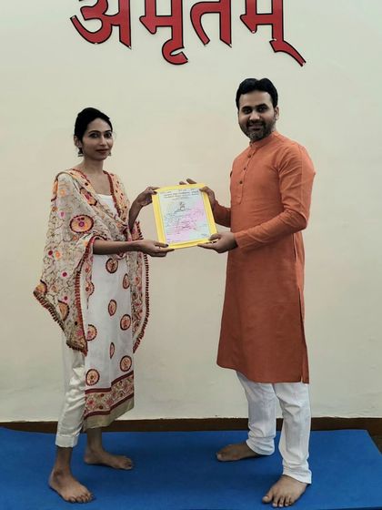 A moment of achievement. This student has successfully completed the rigorous training to become a certified yoga teacher.