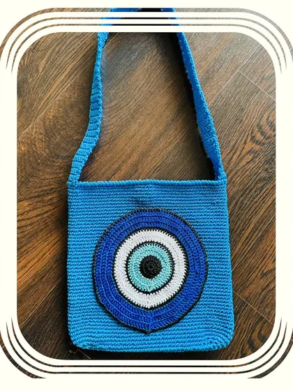 A closer look at the vibrant blue Evil Eye bag. It's a perfect accessory to pair with comfy denims or joggers to up your fashion game.