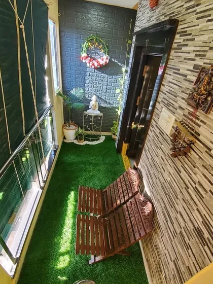 Even a very narrow balcony has great potential. I maximized this space with wall-to-wall artificial grass, a foldable wooden bench for seating, and a mix of wall decor and small plants to create a charming and usable green corner.