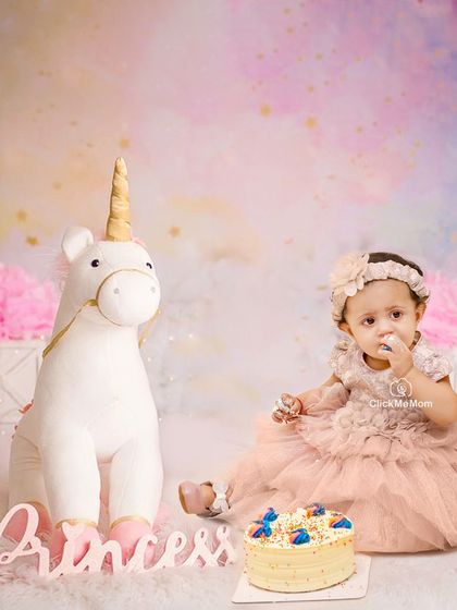 A magical unicorn-themed cake smash for a little princess. The soft pastel colors and whimsical props make for a truly enchanting first birthday portrait.