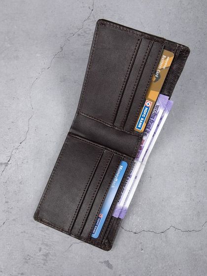 An open view of the dark brown wallet, showing its card and cash capacity.