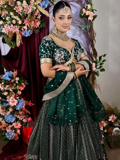 A rich, emerald green lehenga with gold embroidery. This is a classic and regal choice for a sangeet or wedding reception.