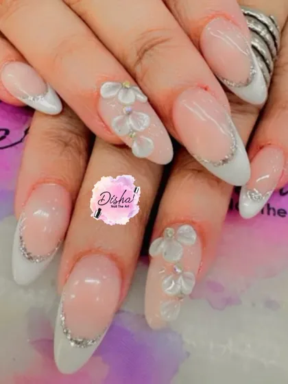 A delicate and pretty design. This set features a soft pink base with a classic French tip, accented with tiny 3D flowers for a touch of subtle elegance.
