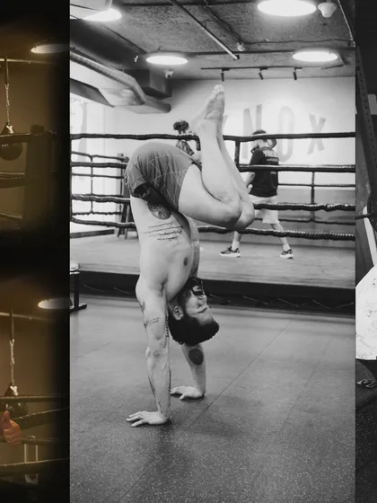 A black and white shot of a handstand, emphasizing the muscular definition and control required for advanced calisthenics.