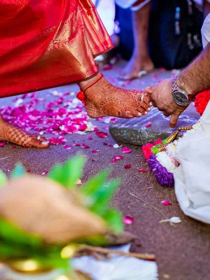 A close-up of a wedding ritual, focusing on the bride's feet and the cultural traditions of a South Indian wedding.