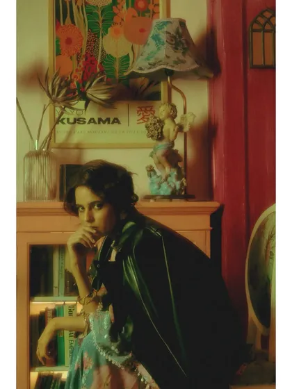 The styling here introduces a leather jacket over a sequined dress, a deliberate clash of textures. This represents the intrusion of a harsher reality into her romantic daydreams.