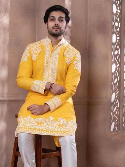 A seated pose in the zesty yellow kurta, showing how the embroidery adorns the garment.