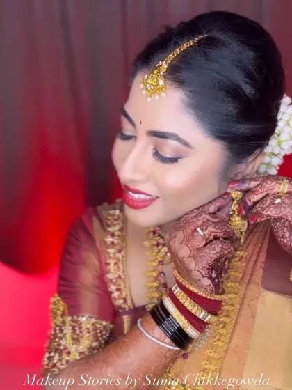 Adjusting the final touches for my beautiful bride Yashaswini. This candid moment captures her glowing skin and the intricate details of her temple jewelry.