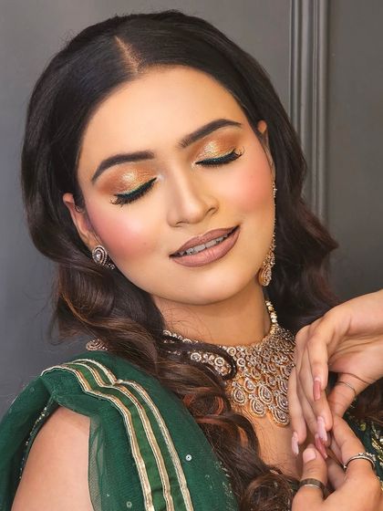 Eyes closed to showcase the beautiful gold and bronze eyeshadow work. This warm-toned eye makeup is versatile and looks stunning with traditional green and gold outfits.