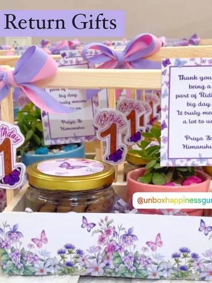 A close-up of the butterfly-themed first birthday return gift, featuring a lavender and pink color palette and a personalized thank you card.