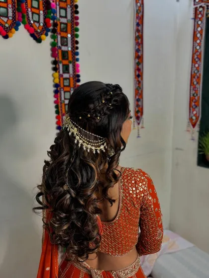 An intricate hairstyle featuring braids and curls, adorned with a beautiful traditional hair accessory.
