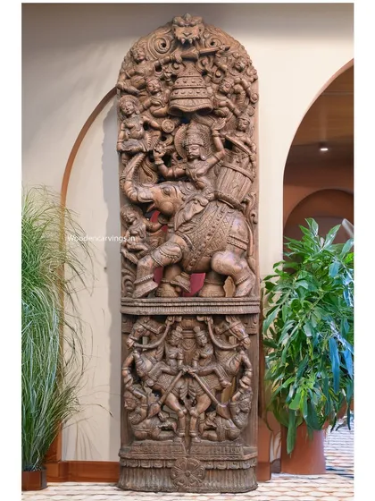 The 83-inch Raj Bhavani wall mount, viewed from a slight angle. This perspective emphasizes the depth of the carving and its impressive presence within an arched entryway, showcasing its architectural impact.