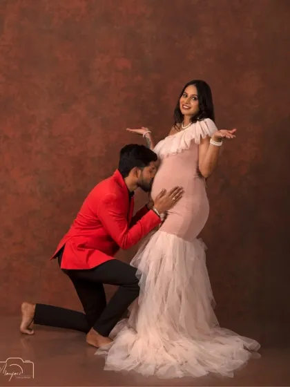 A fun and playful moment as the dad-to-be listens to the baby bump. The elegant setting adds a touch of sophistication to this sweet, candid-style shot.