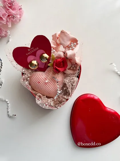 A heart-shaped tin filled with little treasures like earrings and a candle, a perfect small gift to say 'I love you'.