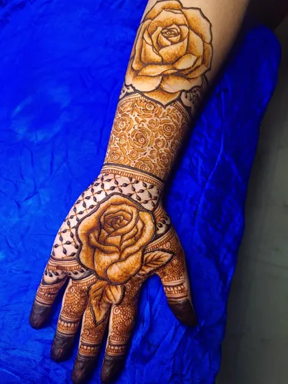 A practice piece blending contemporary and traditional styles. This design features a large, bold rose as the centerpiece on both the palm and the forearm, surrounded by classic patterns.