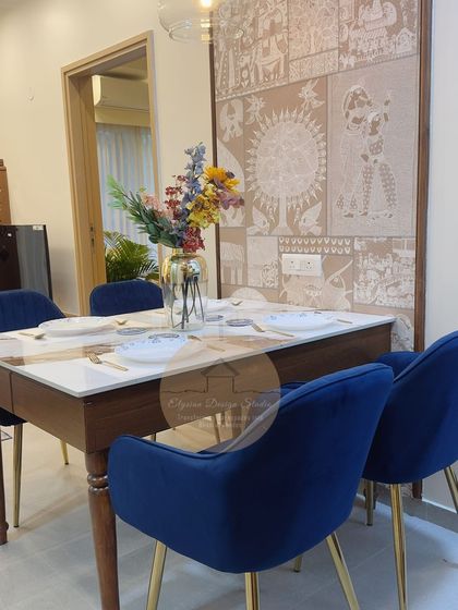 This dining area features a stunning custom wallpaper that acts as a piece of art. The solid wood dining table is paired with royal blue velvet chairs, creating an elegant space for meals and gatherings.