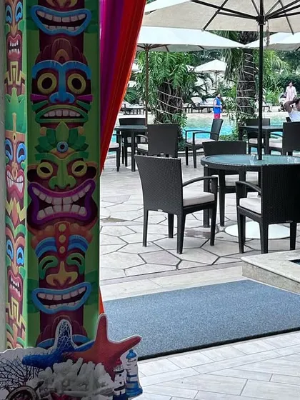 Thematic details extend to the entrance. For this beach party, we used tiki-style pillar wraps and a directional signpost with beach-related phrases to welcome guests into the themed environment.