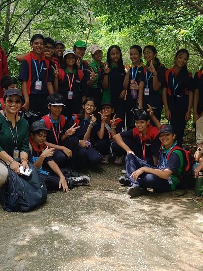 A happy group of students from VIBGYOR High and our team pose for a photo in a shaded part of the Aravalli Biodiversity Park.