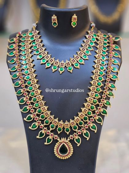 A grand bridal set with multiple layers of necklaces featuring a green leaf motif design.