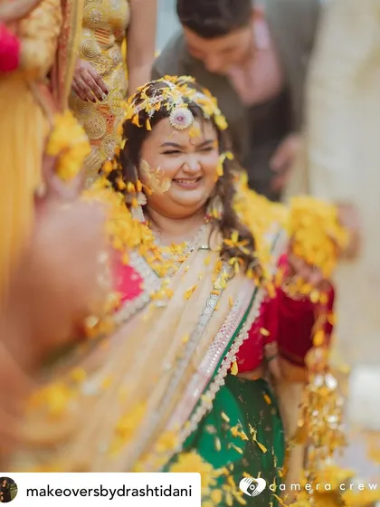 A joyful, candid shot from the Haldi. The makeup is designed to be resilient and beautiful, even during the most fun and messy parts of the celebration.
