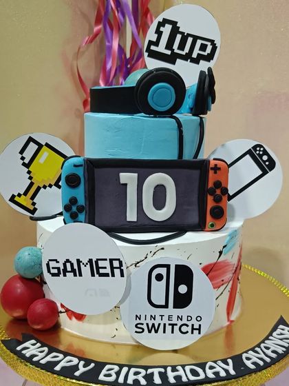 Level up your birthday with this Nintendo Switch gamer cake. The design features fondant joy-cons, a headset, and other gaming-related icons.