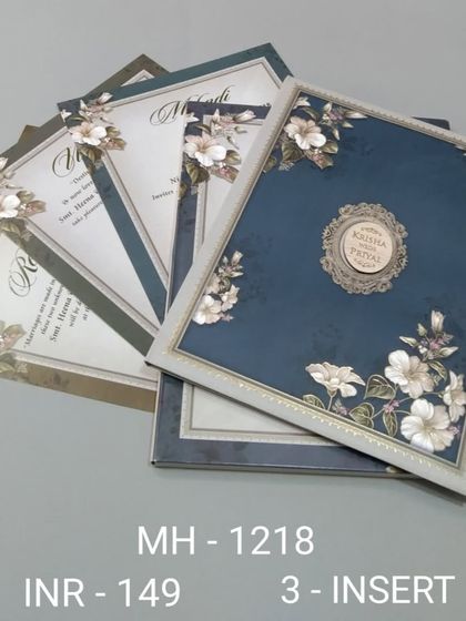 A sophisticated invitation set in a deep blue, featuring a border of white flowers. The set includes three inserts, making it perfect for a multi-event wedding.