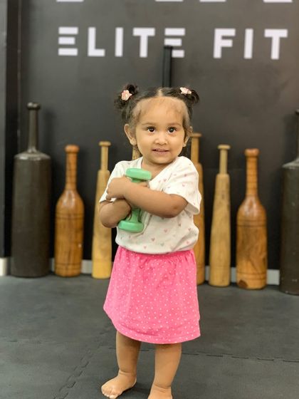 My daughter is ready for her workout, holding a dumbbell at the studio.