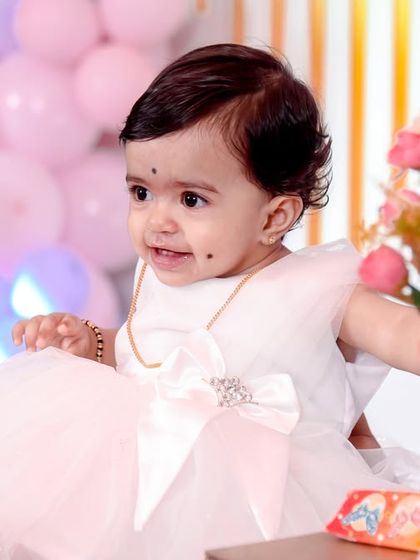 An adorable close-up of a one-year-old birthday girl, looking curious and sweet.