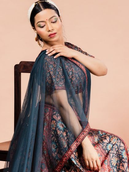 A close-up of a model in a printed lehenga, focusing on the makeup and elegant pose.