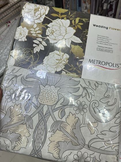 For a bolder look, this Metropolis 'Wedding Flowers' bedsheet set features a striking contrast of gold and white florals on a dark background. It's a statement piece for sure.