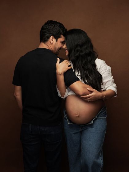 A quiet, intimate moment between the couple, their connection beautifully captured against a simple, warm backdrop.