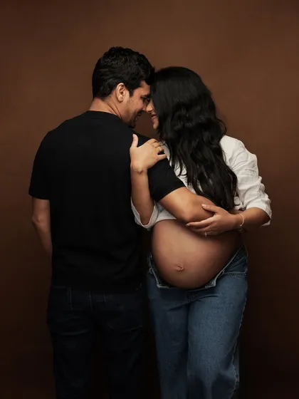A quiet, intimate moment between the couple, their connection beautifully captured against a simple, warm backdrop.