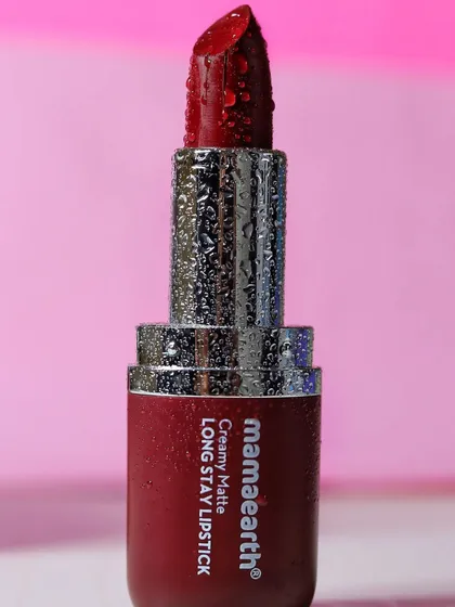 A full view of the Mamaearth Creamy Matte Long Stay Lipstick, with water droplets on the casing to give it a premium, fresh look.