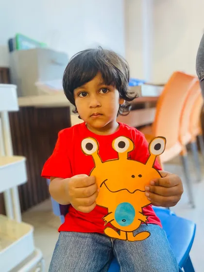 This little boy holds up his finished alien craft for the camera, a moment of pride and accomplishment.