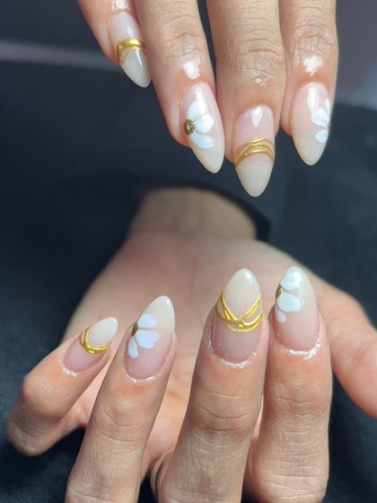 A delicate design with a milky white base, subtle hand-painted white flowers, and gold band accents.