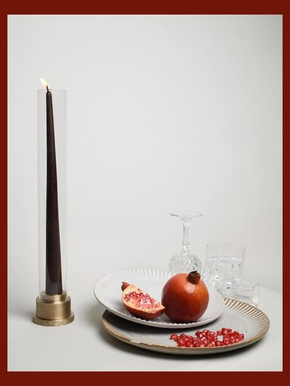 A clean, minimalist catalog shot for Byaas Home. This image isolates the modern glass and brass candle holder against a simple background, emphasizing its sleek design and form, perfect for e-commerce.