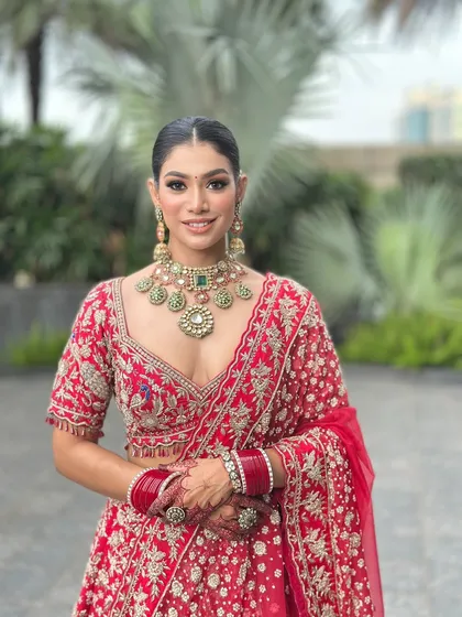 A full portrait of my beautiful bride in a classic red lehenga. I focused on creating a luminous skin finish and defined eyes to complement her traditional wedding attire and heavy jewellery, ensuring she looked absolutely regal.