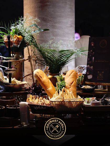 A wide shot of a beautifully arranged buffet table, featuring a variety of breads, cheeses, and other appetizers. Our spreads are designed to be abundant and visually appealing.