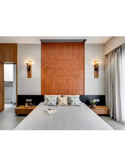 This bedroom features a headboard made of patterned brick tiles, creating a unique textural element that contrasts with the smooth white walls.