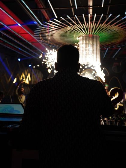 A silhouette against the sparks and lights. This captures the explosive energy of a peak-time set, where the music and visuals come together for a powerful impact.