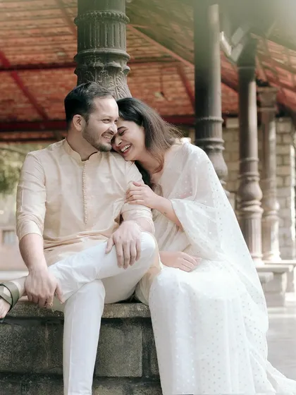 A happy, relaxed couple sitting on a stone bench, their easy laughter filling the air.